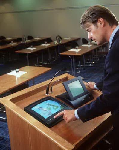 Picture of man at podium using laptop